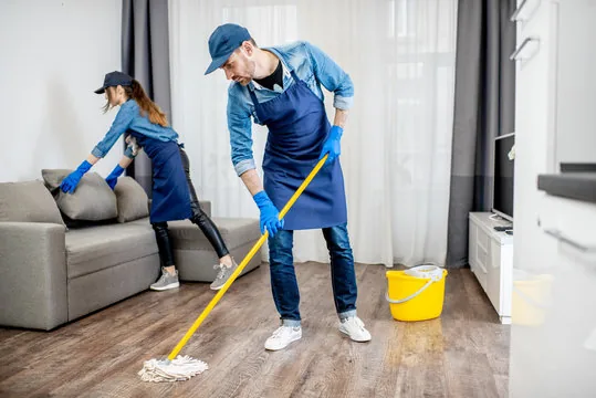 CleanPro Plus cleaning team tidying a residential living room